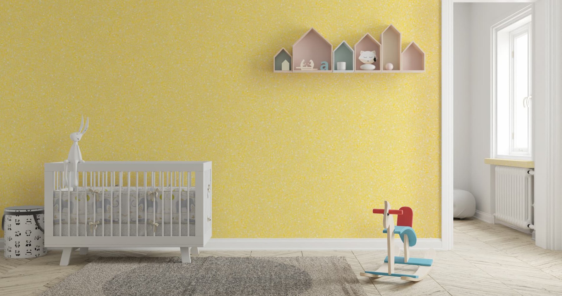 Ein sonniges Babyzimmer mit einer nachhaltigen Belka Tapete in warmem Gelb, zuhause einem weißen Babybett und liebevollen Dekorationen.