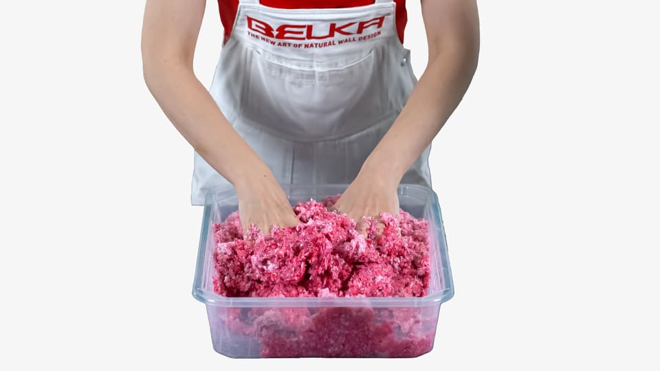 A woman kneads a mixture of Belka and water. The color of the product is pink.