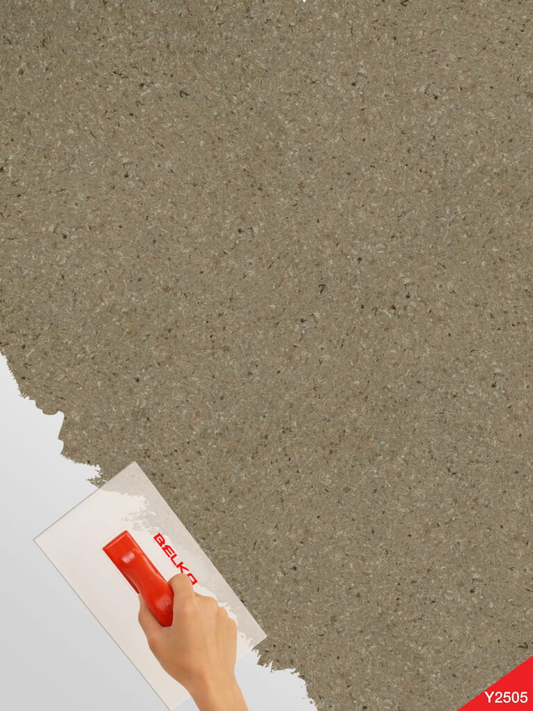 Karamellbeige Belka Y2505 Tapete auf einer modernen Wohnzimmerwand. Die warme, strukturierte Oberfläche harmoniert mit Holz- und Cremetönen, schafft eine gemütliche, elegante Atmosphäre. Im Licht schimmert die Tapete sanft und betont natürliche Wärme.