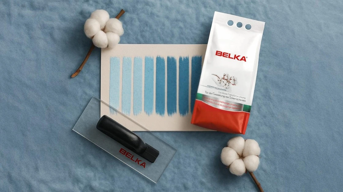 Belka Wandbeschichtung in Blautönen mit Musterkarte, Belka-Packung und Kunststoffkelle auf blauem Hintergrund